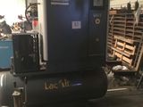un gros compresseur d'air posé sur une palette dans un entrepôt