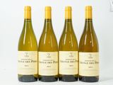 quatre bouteilles de vin sont alignées sur une surface blanche