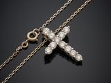 a diamond cross pendant on a gold chain