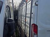 two white vans parked next to each other in a field