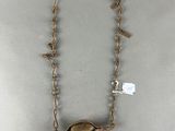 an image of a necklace with a shell on a chain