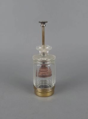 un petit bocal en verre muni d'un couvercle en bois et d'une poignée en métal