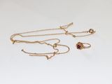 un gros plan d'un collier et d'une paire de boucles d'oreilles posés sur une surface blanche