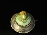 a close up of a small figurine sitting on top of a silver plate