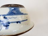 Quelqu'un tient un bol bleu et blanc orné d'un motif.