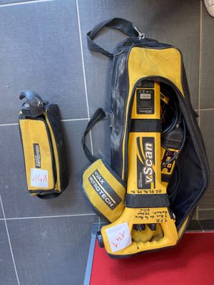 un sac jaune et noir et quelques outils posés sur un tapis rouge