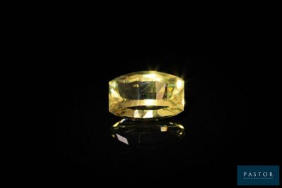 un diamant jaune sur une surface noire dans l'obscurité