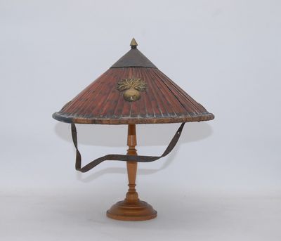 a wooden table lamp with a red shade on top of it