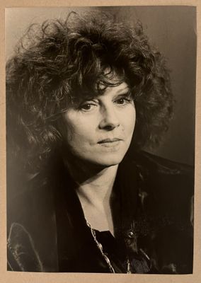 une vieille photo en noir et blanc d'une femme aux cheveux bouclés