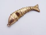 a gold fish shaped object on a white surface