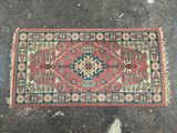 un gros plan d'un tapis posé au sol, avec une personne debout à côté