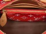 the inside of a red louis vuitton handbag with gold hardware