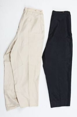 deux paires de pantalons noirs et blancs posés sur une surface blanche
