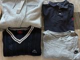trois polos pour homme disposés sur un lit devant une fenêtre
