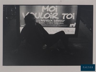 photo en noir et blanc d'un homme assis devant un téléviseur