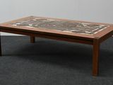 a coffee table with a tile top on a carpeted floor