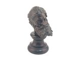 une statue représentant un homme barbu sur un socle