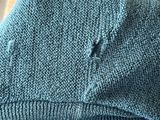 a close up of a sweater with a hole in the back