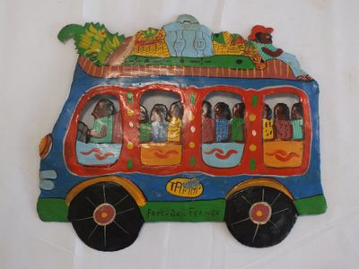 un petit bus avec des personnages assis dessus, posé sur une surface blanche