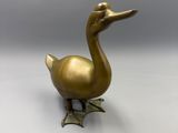 brass duck figurine on a white background