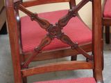 four wooden chairs with red upholstered seats in a room
