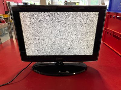 un téléviseur posé sur une table rouge dans une pièce