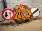 three road signs that are on display in front of a wall
