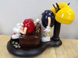 a figurine of a person sitting on a couch with a balloon