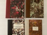 quatre livres sont alignés sur une surface blanche