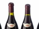 three bottles of wine are lined up on a white surface