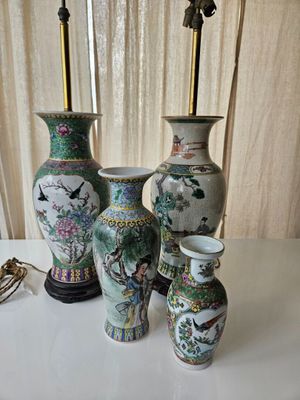 four vases sitting on a table with a lamp on top of them