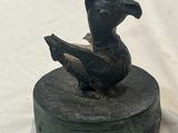 statue of a duck sitting on top of a box on a white surface