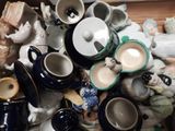 many cups and saucers sitting on a table