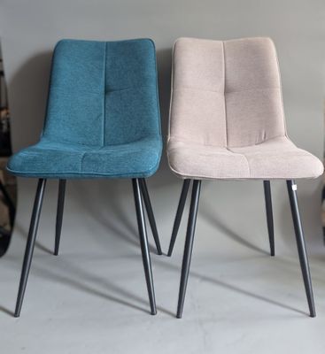 three different colored chairs sitting next to each other on a white surface