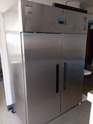 a stainless steel refrigerator in the middle of a room