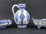three pieces of blue and white porcelain on a black background
