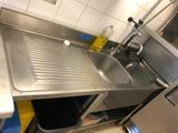 un évier de cuisine avec une poubelle à côté