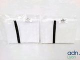 two bags of white paper with black ribbon on them
