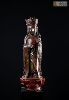 une statue en bronze représentant un Bouddha assis sur un fond noir