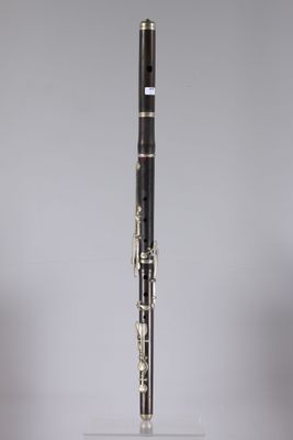 a close up of a black and gold clarinet on a clear stand