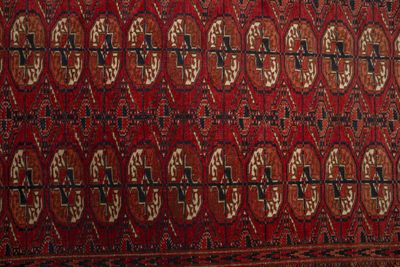 une photo d'un tapis rouge et noir orné d'un motif