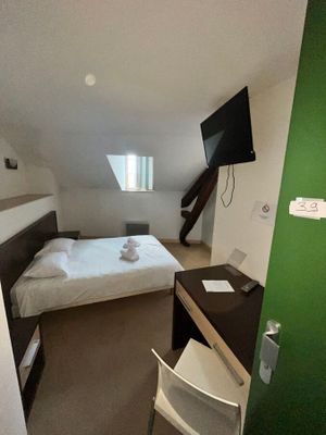 une chambre équipée d'un lit, d'un bureau et d'une télévision