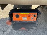 a close up of a person holding a tool box under a vehicle
