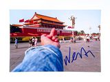 a picture of a person holding their hand up in front of a building
