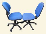 two blue office chairs sitting next to each other on a white surface