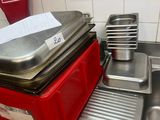 Plusieurs casseroles et poêles sont empilées sur un plan de travail dans une cuisine.