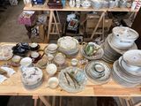 many plates and bowls on a table in a room