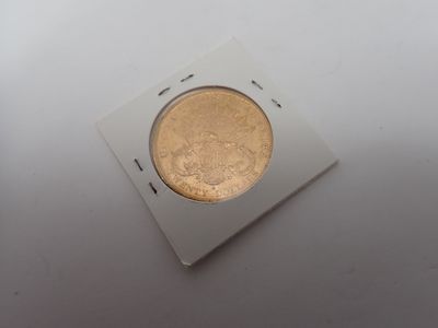 un gros plan d'une pièce de monnaie dans une boîte blanche posée sur une table