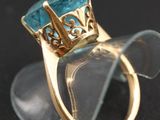 an image of a gold ring with a blue topaz stone