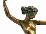 bronze statue of a woman sitting on a rock with her arms outstretched